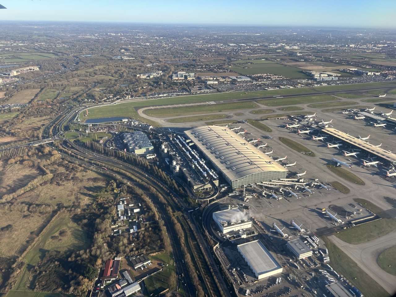 Aerial view of a major UK airport with aircraft at their stands
